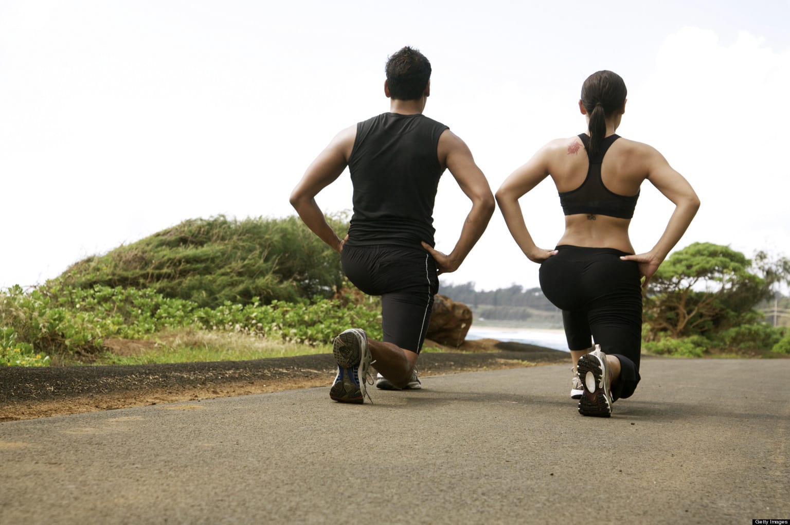 Hawaii, Kauai, Kealia Beach, Young fit couple doing lunges or sqauts.