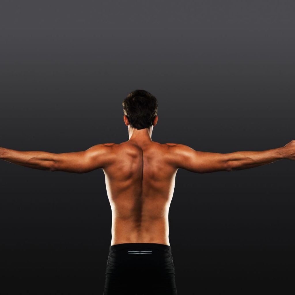 the back of a fit man stretching arms out